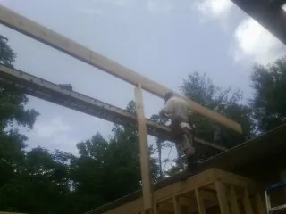 Carpenter setting a ridge beam over a new addition frame — Ice Dam Removal by Roofing Brothers in Elkhart
